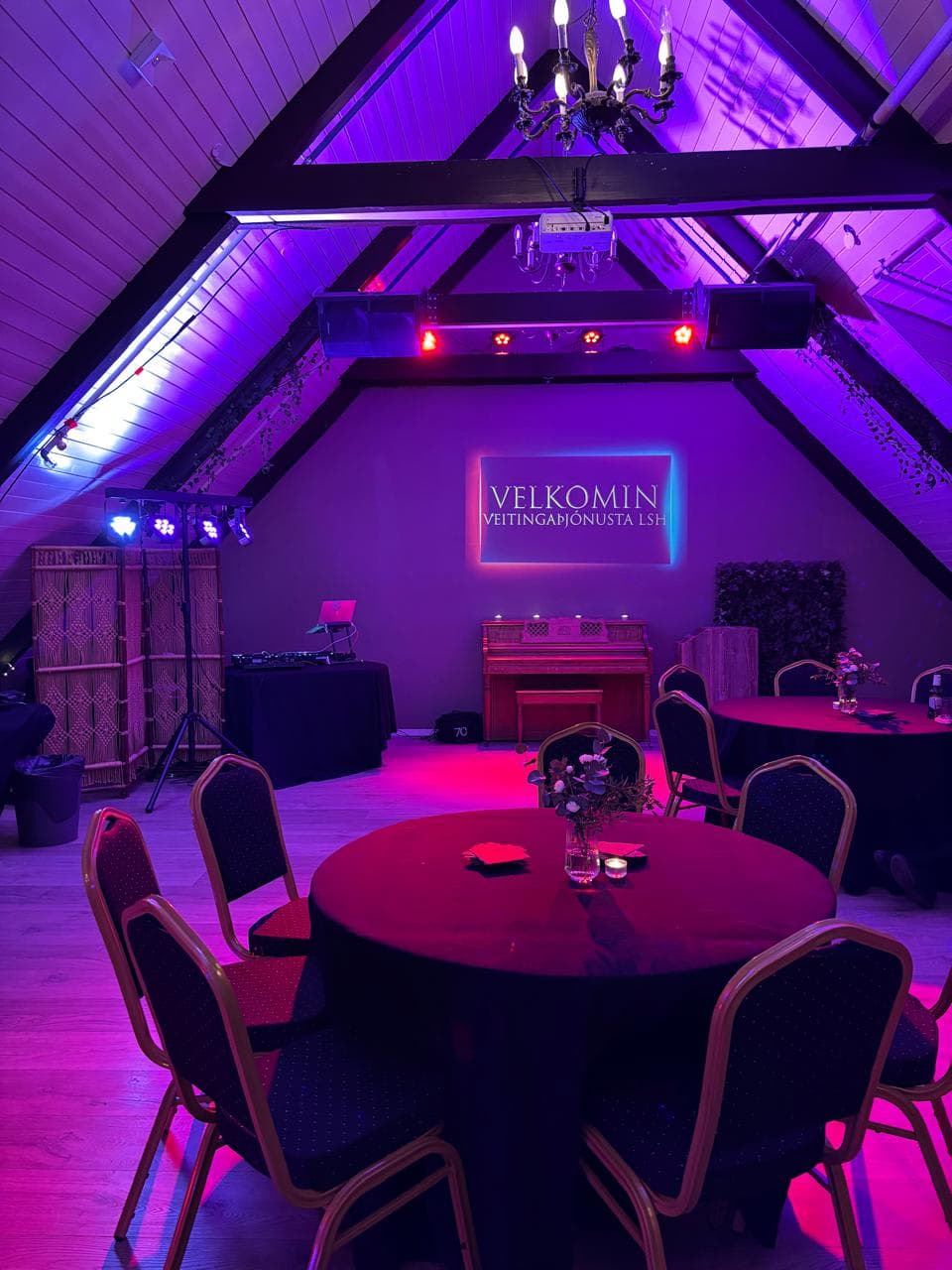 Kornhlaðan with tables, projector, and purple lighting